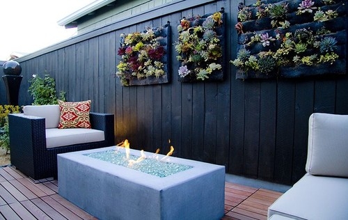 vertical pallet garden black wooden wall armchair white cushion outdoor fireplace