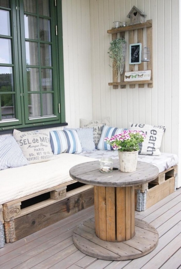 mesa de carrete de alambre sofá de paleta reutilizado almohadas blancas centro de mesa de flores